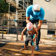Before hitting the water, we practice key movements on the deck. Here, I'm helping a young student with posture to ensure they are ready for the pool.