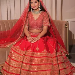 Here is the full view of the classic red bridal lehenga. The flowing A-line skirt and matching sheer dupatta create a look that is both traditional and breathtakingly beautiful.