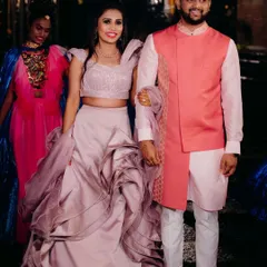 I love creating looks for every function. For this sangeet ceremony, I designed a contemporary layered outfit featuring a stylish pink jacket over a light kurta, perfectly coordinated with his partner's sculpted lehenga for a vibrant, modern couple's statement.