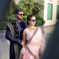 A cool and stylish pre-wedding portrait. The sunglasses add a modern touch to the couple's traditional outfits, showing off their fun personality.