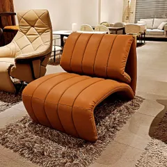 A live look at the 'GRFIT' lounge chair in a rich tan leatherette. The channel-stitched design adds texture and comfort, while the unique shape makes it a conversation starter.
