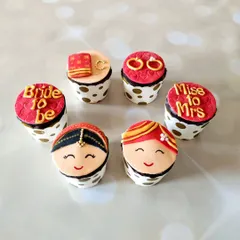 These cute cupcakes were made for an engagement ceremony. The toppers include a bride and groom, wedding rings, and a "Bride to be" message, all handcrafted from fondant.