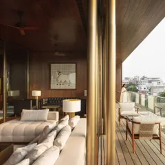 The formal living room seamlessly extends onto a spacious wooden deck. This indoor-outdoor space is designed for entertaining guests or enjoying quiet family evenings, surrounded by views of the city.