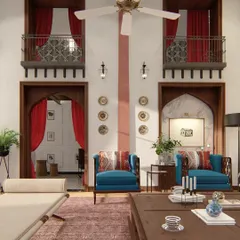 This view highlights the double-height space, with traditional jharokha-style balconies overlooking the main seating area. The design uses a mix of bold colors like red and blue to energize the space.