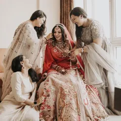 The bride surrounded by her bridesmaids. Their shared laughter and joy as they help her get ready is a perfect memory of friendship and celebration.