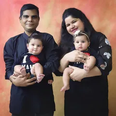 Not double trouble, but twice blessed! A happy family portrait with their adorable twin babies wearing cute "I ❤️ Mom" and "I ❤️ Dad" shirts.