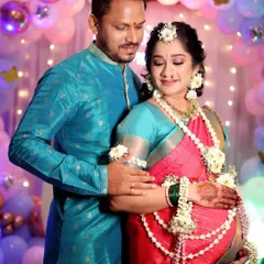 Capturing the joy and anticipation of new parents. The mom-to-be's look is complete with a beautiful saree drape that is comfortable for her, glowing makeup, and traditional flower jewelry, making her feel special on her big day.