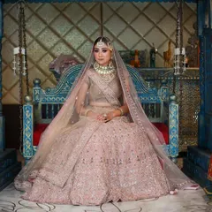 A wide shot capturing the full grandeur of the pink bridal lehenga, with the model framed by traditional puppets for a culturally rich setting.
