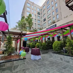 For a milestone 50th birthday brunch, I used a 'ColourPOP' theme to create a vibrant and joyful atmosphere. The outdoor venue was styled with colorful drapes and paper lanterns, transforming the space into a lively celebration.
