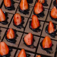 A dessert island of chocolate and strawberries. These rich chocolate mousse squares are topped with fresh strawberries for a classic and irresistible combination.