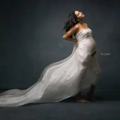 Power and grace in a single frame. This full-body portrait uses chiaroscuro lighting to sculpt the mother's form, highlighting her strength and the beauty of her pregnancy.