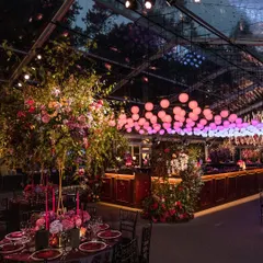A moody, dramatic Sangeet inspired by the romance of Bridgerton. This setup in the British countryside features a clear-span marquee, lavish floral arrangements, and custom lighting to create a truly immersive, high-energy atmosphere.