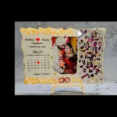 This is a perfect example of how we can combine memories. I preserved varmala petals on one side and created a custom calendar marking the wedding date on the other, all framing a beautiful wedding photo. It’s a functional and sentimental piece for your home.