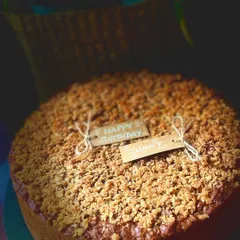 Another shot of the apple cinnamon cake with its generous crumble topping, complete with a custom "Happy Birthday" tag.
