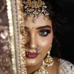This half-face portrait showcases the precision of bridal eye makeup, with a peek of the ornate maang tikka and dupatta.