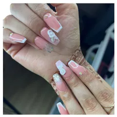 Elegance for a special occasion. These coffin-shaped nails feature a French ombre base with silver glitter accents, 3D white floral designs, and a touch of sparkle from tiny rhinestones.