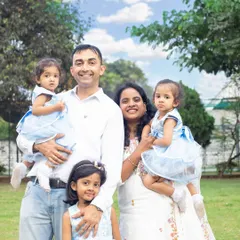 A lovely family enjoying a day in the park. The coordinated outfits and the beautiful natural light make this a perfect outdoor family photo.