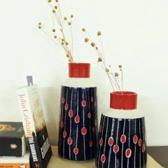 Styled on a bookshelf, the Dew Drops vases show how functional art can elevate your home decor. Each vase is wheel-thrown and painted by hand, making it a unique accent piece.