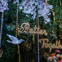 A close-up of a neon sign that reads 'Better Together', set against a beautiful foliage backdrop. I use these details to add a modern and personal touch to your decor.