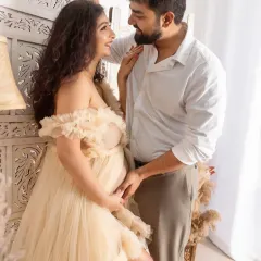 A bright and airy couple's portrait with a bohemian feel. The couple shares a loving gaze, surrounded by natural textures and soft lighting in the studio.