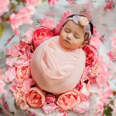 Surrounded by a bed of pink flowers, this baby girl looks like a sleeping angel. Floral themes are a beautiful way to add color and softness to your newborn's portraits.