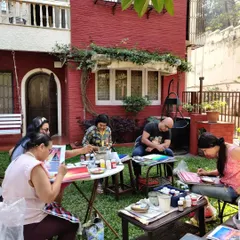 A group of adult students completely absorbed in their art during one of our outdoor workshops. The garden setting provides a tranquil and inspiring atmosphere.