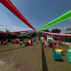 I can transform large outdoor spaces for any celebration. Here, I used a canopy of vibrant, multi-colored drapes over a lawn for a mehndi or Holi party, creating a festive and energetic atmosphere for a big gathering.