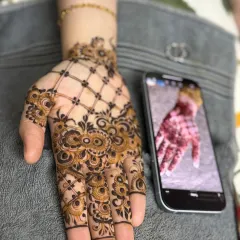 A classic 'jaal' pattern on the back of the hand, combined with intricate cuff detailing. This style is elegant and timeless.