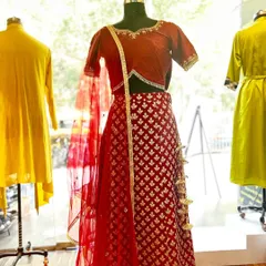 Your dream wedding lehenga, designed just for you. This red brocade lehenga with a matching blouse and net dupatta is a perfect example of classic bridal elegance.