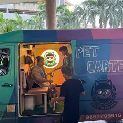 We love welcoming you and your pet into our mobile salon. Here, a client is comfortably seated inside our van while her dog gets ready for its grooming session.
