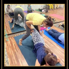 I provide a hands-on assist for a spinal twist, ensuring the student gets a safe and effective release in her lower back.