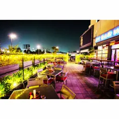 The illuminated planters on the terrace of My Bar Headquarters demonstrate how a rooftop garden can become a key feature of a venue's nightlife appeal, providing a beautiful backdrop for evening patrons.