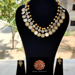The terracotta coin necklace displayed on a bust, showing how it sits elegantly on the neckline. This helps buyers visualize how the product will look when worn or displayed.