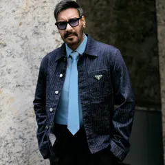 A close-up shot that highlights the texture of the Prada jacket and the cool tone of the blue tie.