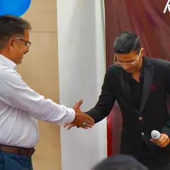 A handshake of appreciation after a successful mind-reading demonstration at Kusum Healthcare. The connection with the audience is key.
