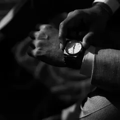 A classic, moody black and white shot focusing on the groom adjusting his watch. It’s a small moment that speaks of anticipation and timeless style.