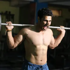 As a national-level competitor, I lead by example. This shot from a heavy squat session shows the intensity and focus required to build a powerful lower body, a critical component of a balanced, competitive physique.