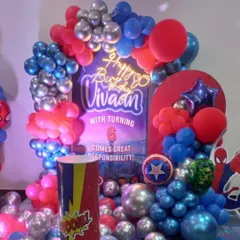 A close-up of the Avengers birthday setup, showing the 'Happy Birthday' neon sign and balloon details. The red, blue, and silver colors are inspired by heroes like Captain America and Spider-Man.