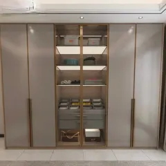 This elegant wardrobe features a central glass display section with gold-finish metal frames, perfect for showcasing bags and accessories. The internal drawers are well-organized.