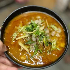 A comforting bowl of our Nalli Nihari. This traditional slow-cooked lamb shank stew is rich with aromatic spices and garnished with fresh ginger and cilantro, perfect with our butter tandoori roti.