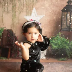 A beautiful, expressive portrait of the birthday girl. The soft lighting and magical sparkles add a dreamy touch to her first birthday photos.