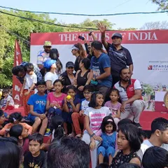 We manage interactive and family-friendly public events. This photo captures the fun at a community gathering we organized, complete with a stage for announcements and activities for all ages.