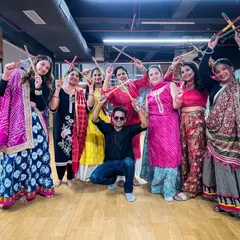 The pure joy and energy of a Dandiya workshop. This group shot captures the participants posing with their dandiya sticks after a fun-filled session of learning and dancing together.
