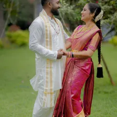 A joyful, candid moment of a couple holding hands and sharing a laugh in a beautiful green garden. This is the essence of capturing your natural chemistry.