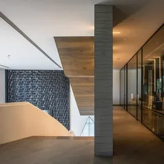 Inside the Hoshiarpur office, I used a combination of clean lines, textured walls, and a striking staircase to create a sense of modern sophistication. The glass-walled corridor maintains an open feel while delineating different functional zones.