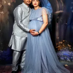 A royal-themed couple maternity portrait. The expecting parents pose together in coordinated silver and blue outfits.