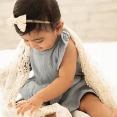 This little girl is fascinated by the lace blanket. Sitter sessions are full of discovery, and I let babies play and interact naturally with their surroundings.