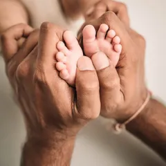 A father's hands gently holding his baby's feet. A simple, powerful image of paternal love.