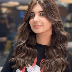 A portrait of the finished ash brown look. The face-framing layers and soft waves perfectly complement the dimensional hair color.