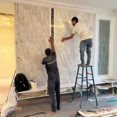 Precision is everything. Here, our team is installing a statement wall, ensuring every panel aligns perfectly. This is where our design-and-build model shines; the same team that envisions the detail also executes it flawlessly on site.